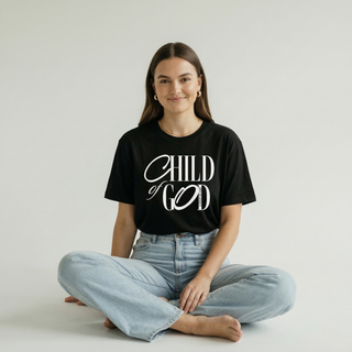 Front view of black "Child of God" Christian calligraphy graphic tee showing elegant script design, paired with light blue jeans