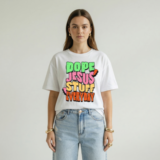 Woman standing wearing the Dope Jesus Tee in white, featuring bold colorful "Dope Jesus Stuff Everyday" graphic print, paired with ripped wide-leg jeans