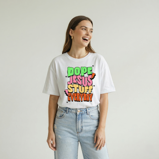 Smiling woman standing and wearing the Dope Jesus Tee in white with colorful street-style "Dope Jesus Stuff Everyday" graphic, styled with light wash jeans