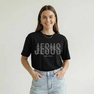 Woman smiling in black "Jesus Saves" Luke 19:10 Christian graphic tee with layered text design, styled with light denim jeans