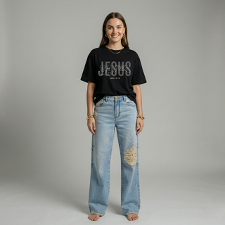 Full body view of woman in oversized black "Jesus Saves" Christian graphic tee paired with wide-leg ripped denim jeans
