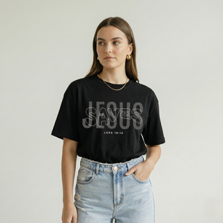 Close-up upper body view of woman in black "Jesus Saves" Luke 19:10 Christian graphic tee showing the bold JESUS SAVES layered text design, cropped to waist