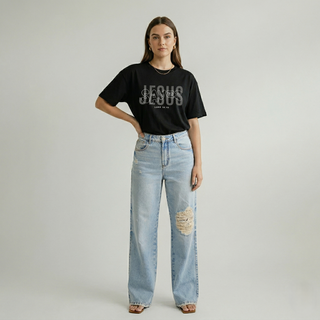 Full body view of woman with hand on hip in black "Jesus Saves" Luke 19:10 women's Christian faith graphic tee, styled with light wide-leg ripped denim jeans