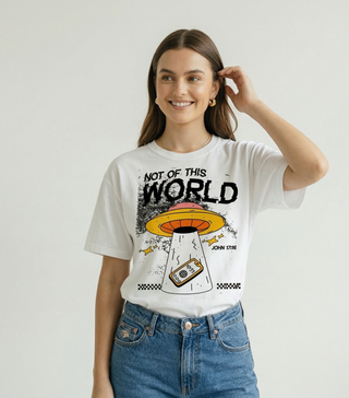 Woman in white "Not of This World" John 17:16 Christian graphic tee with UFO design, paired with blue denim jeans