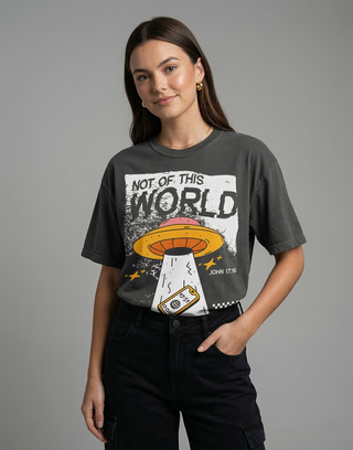 Woman in charcoal "Not of This World" John 17:16 Christian graphic tee styled with black cargo pants on gray background